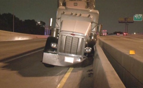 A pedestrian walking on the freeway caused a semi truck driver to swerve and crash into the concrete median barrier in Houston, TX on May 22, 2013. Photo credit: KHOU.com