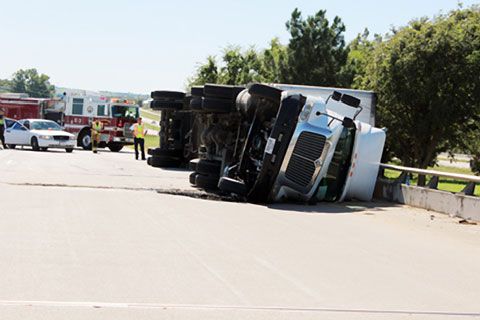 A semi truck overturned after rounding a curve at the U.S. Highway 287 / I-35E interchange in Waxahachie, TX on October 8, 2013. Photo credit: Andrew Branca / Waxahachie Daily Light 